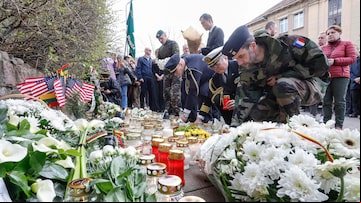 Soldados ses e de outros países da Otan depositam flores e velas do lado de fora da Embaixada dos EUA em Vilnius, Lituânia, para prestar homenagem aos soldados americanos que morreram em um campo de treinamento.